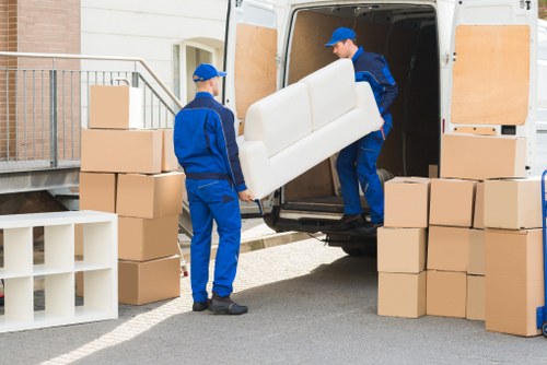 Staff using safety equipment while loading a removals vehicle