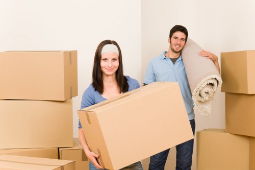 Professional movers carrying a sofa through a residential property in Croydon